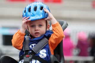 Kid in child seat at a HSBC UK Let's Ride event.