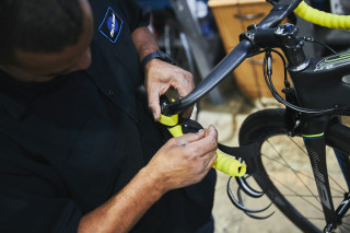 A mechanic wrapping new handlebar tape