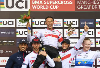 The GB men's team lift Kye Whyte in the air after winning round two of the UCI BMX Supercross World Cup in Manchester 2019.