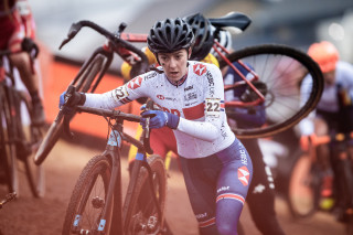 Beth Crumpton carrying her bike during a cyclo-cross race