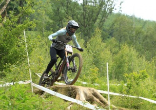 A downhill rider mid-air after hitting a jump