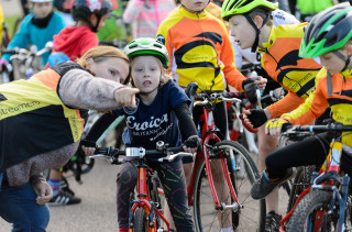 Volunteers helping a child to cycle