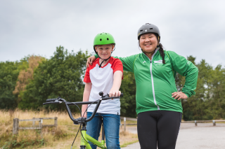 A female ride leader and young rider, posing mid-ride