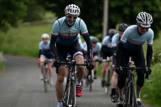 A group of cyclists on a country road.